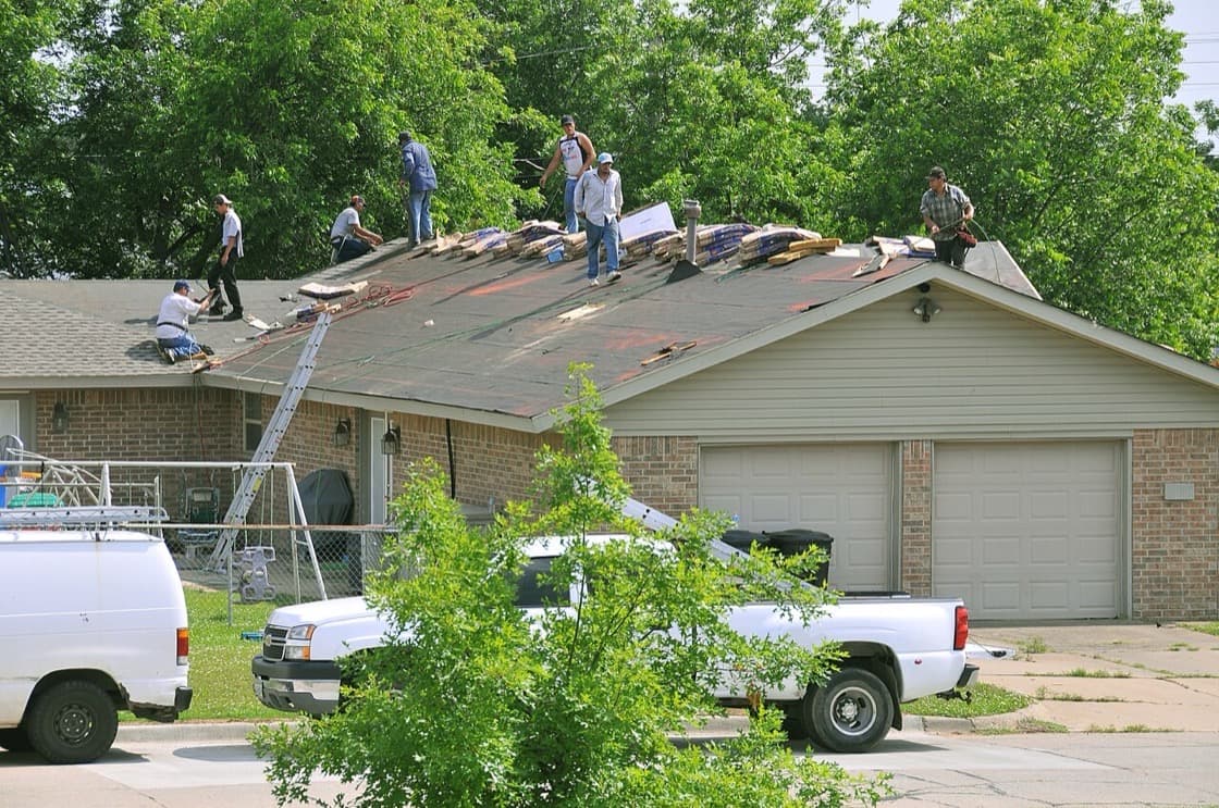A roofing crew at work on a house roof
